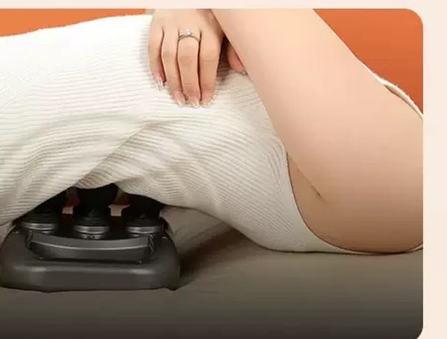 Person lying comfortably with the SixPoint body massager tucked under their lower back
